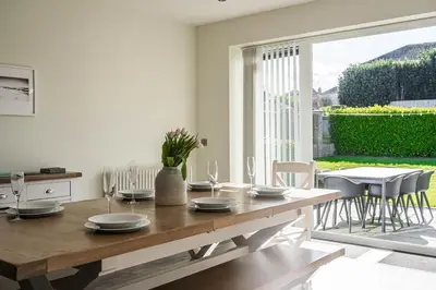 a dining room with a wooden table and a large window at Old School Mews - Shanklin - Dog Friendly in Moffat