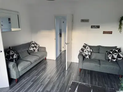 a living room with two couches and a mirror at Rowe Terrace Workington in Workington