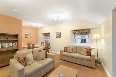 a living room with two couches and a dining room at 1 Harney Peak in Portinscale