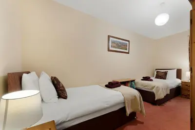 a bedroom with two beds and a mirror at 1 Harney Peak in Portinscale