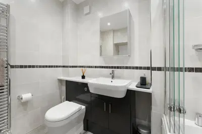 a white bathroom with a toilet and a sink at 1 Harney Peak in Portinscale