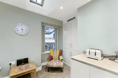 a kitchen with a chair and a clock on the wall at 1 Harney Peak in Portinscale