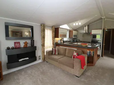 a living room with a couch and a kitchen at No 8 Hillcote Lodge in Cockermouth