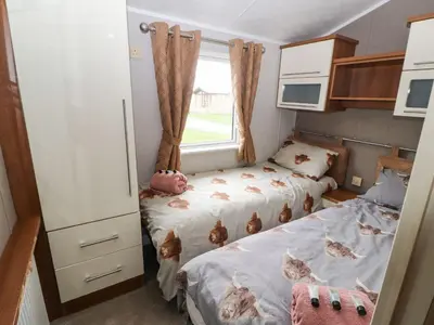 a small room with two beds and a window at No 8 Hillcote Lodge in Cockermouth
