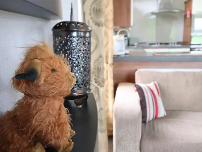 a stuffed animal sitting on a table next to a couch at No 8 Hillcote Lodge in Cockermouth