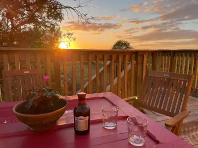 a bottle of wine sitting on a table on a deck at West Coast Whistlestop in Ochiltree