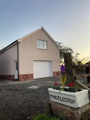 a house with a garage and a flower pot at West Coast Whistlestop in Ochiltree