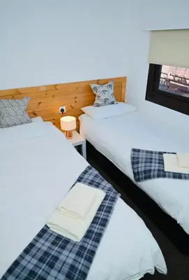 two beds sitting next to each other in a room at Lodge Cabin with Fabulous Views 2 - Farm Stay in Portpatrick