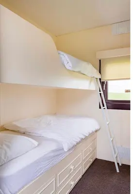 two bunk beds in a room with a ladder at Lodge Cabin with Fabulous Views 2 - Farm Stay in Portpatrick