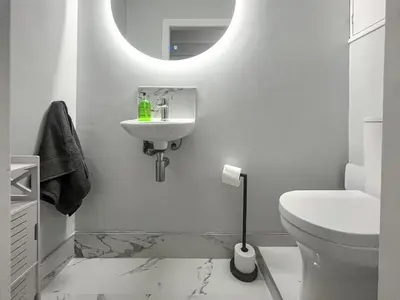 a white bathroom with a sink and a toilet at Lakes And Shores Retreat in Maryport
