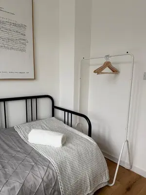 a bed in a room with a mirror next to it at Private Rooms Near Acton Main Line Direct Elizabeth Line to Heathrow in Moffat