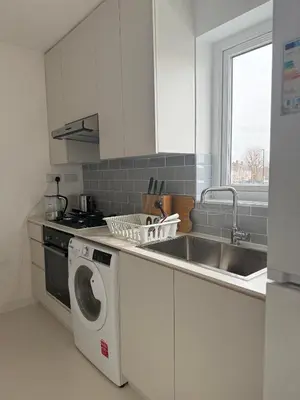a kitchen with a washing machine and a sink at Private Rooms Near Acton Main Line Direct Elizabeth Line to Heathrow in Moffat