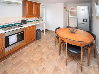 a kitchen with a wooden table and a table and chairs at Derwent View in Applethwaite