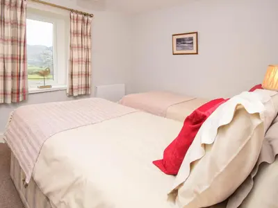 two beds in a room with a window at Derwent View in Applethwaite