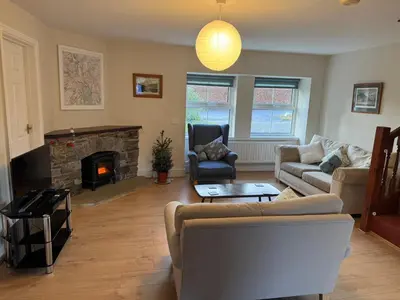 a living room with a couch and a fireplace at Cozy cottage at the base of Sale and Ling Fell in Embleton