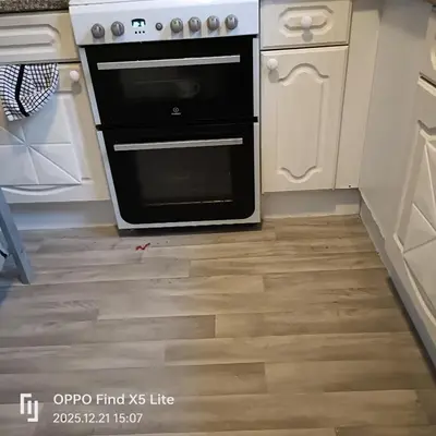 a kitchen with a black oven and white cabinets at Room2let in Moffat