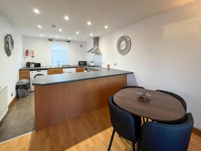 a kitchen with a wooden counter and a table at Graeme-An-Taoiseach Uk50061 in Stranraer