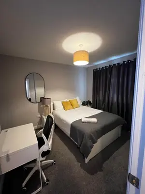 a bedroom with a bed and a desk and a mirror at Ella's Place in Moffat