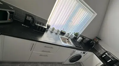 a kitchen with a black counter top and a window at Ella's Place in Moffat