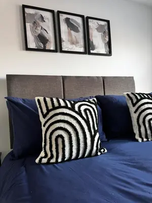 a bed with blue sheets and black and white pillows at Oakleigh Way, Carlisle - 2 Bedroom, sleeps 4, Fully furnished in Carlisle