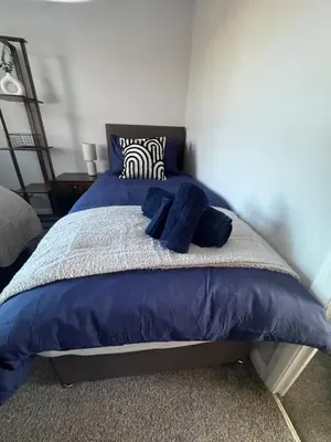 a bedroom with a blue bed with blue pillows at Oakleigh Way, Carlisle - 2 Bedroom, sleeps 4, Fully furnished in Carlisle