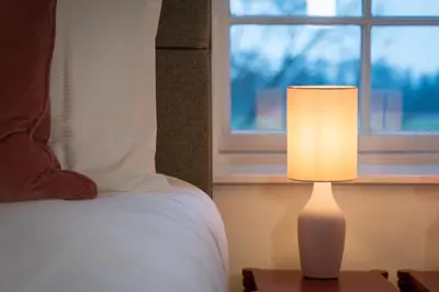 a lamp sitting on a table next to a bed at River View Cottages in Annan
