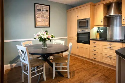 a kitchen with a table with a vase of flowers on it at Scale Hill Hotel in Loweswater
