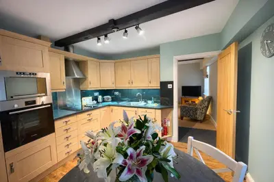 a kitchen with a table with a vase of flowers at Scale Hill Hotel in Loweswater