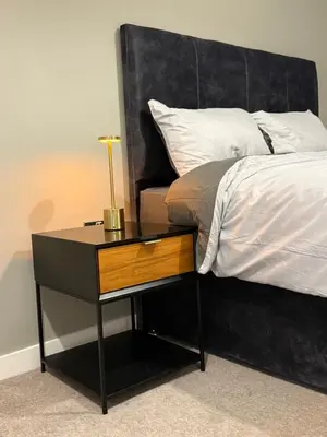 a bed with a nightstand next to a bed with a bedskirts at Chalk in Moffat