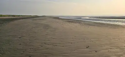 an empty beach with footprints in the sand at One Old Creamery in Sandhead