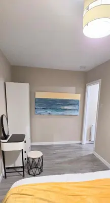 a bedroom with a bed and a desk and a painting at One Old Creamery in Sandhead