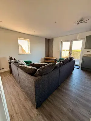 a living room with a large couch in a room at Black Dub Cottage in Allonby