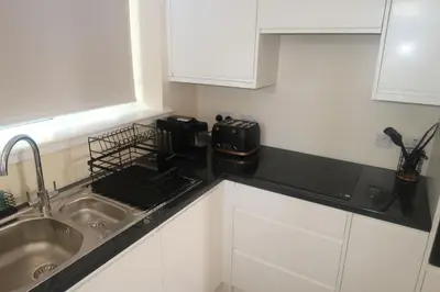 a kitchen with a sink and a toaster on a counter at Luxury one bedroom apartment in Dumfries