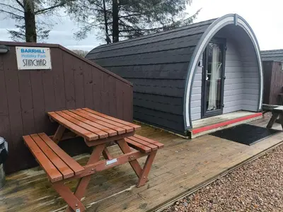a picnic table and bench on a deck with a shed at Barrhill Holiday Park - Glamping in South West Scotland - Duisk in Girvan
