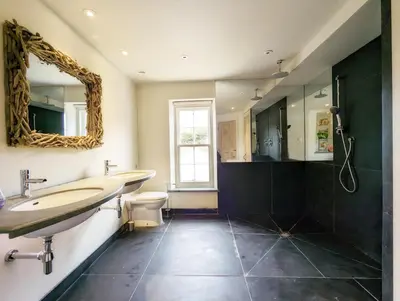 a bathroom with two sinks and a mirror at The Granary in Moffat