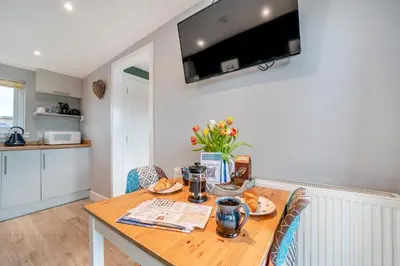 a dining room with a wooden table with food on it at 1 Bed in Gatehouse Of Fleet oc-t34445 in Gatehouse of Fleet