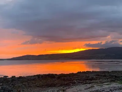 a sunset over a body of water with mountains at 1 Bed in Gatehouse Of Fleet oc-t34445 in Gatehouse of Fleet
