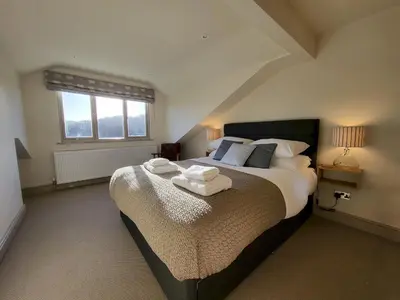 a bedroom with a large bed with towels on it at Wetherlam View Little Langdale in Little Langdale