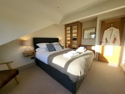 a bedroom with a bed with a shirt hanging on the wall at Wetherlam View Little Langdale in Little Langdale