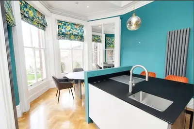 a kitchen with a sink and a blue wall at Portland Square in Carlisle