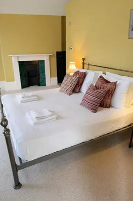 a large white bed with several pillows on it at Portland Square in Carlisle