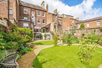 a garden in front of a large brick building at Portland Square in Carlisle