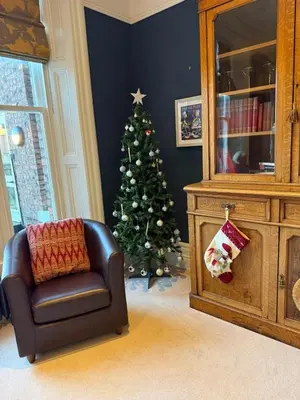 a christmas tree in a living room with a chair at Portland Square in Carlisle