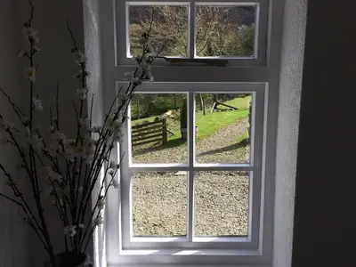 a window with a view of a field outside at High Snab Cottage Newlands Valley in Keswick