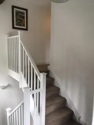 a staircase with white railings and a white stair case at High Snab Cottage Newlands Valley in Keswick