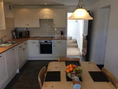 a kitchen with a table with a bowl of fruit on it at High Snab Cottage Newlands Valley in Keswick