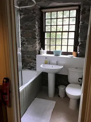 a bathroom with a sink and a toilet and a bath tub at 3 Millbeck Cottage in Keswick