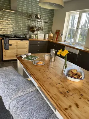 a kitchen with a wooden table with food on it at Keeper's Cottage at Slogarie Estate in Castle Douglas