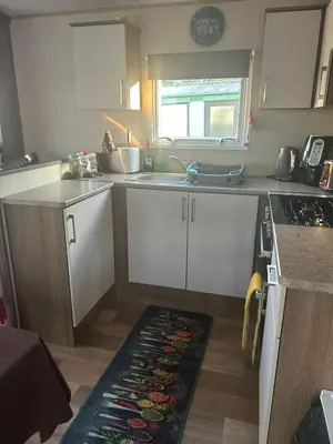 a kitchen with white cabinets and a sink at BZ Green Haven Caravan in Ballantrae