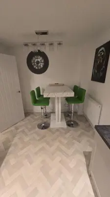 a dining room with a table and two green chairs at 3,Lime Tree Ave in Moffat